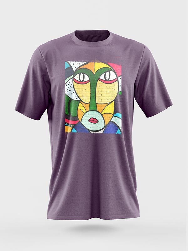 Camiseta morada con un colorido diseño de cara abstracta de estilo cubista en la parte delantera, con atrevidas líneas y formas geométricas en tonos amarillos, verdes, rojos, azules y blancos.