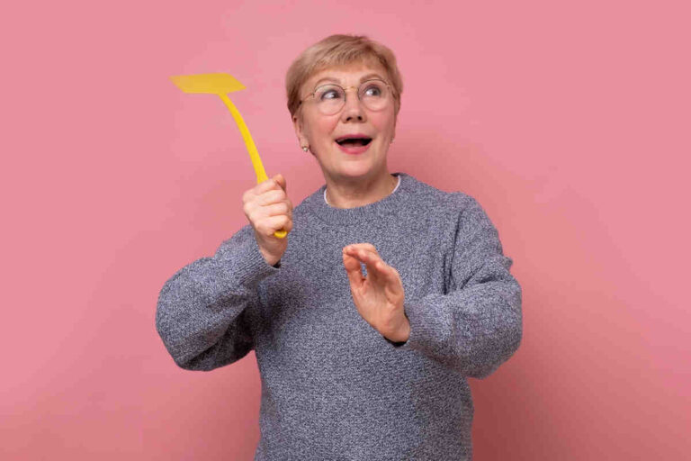 Mujer usando la paleta mata moscas.