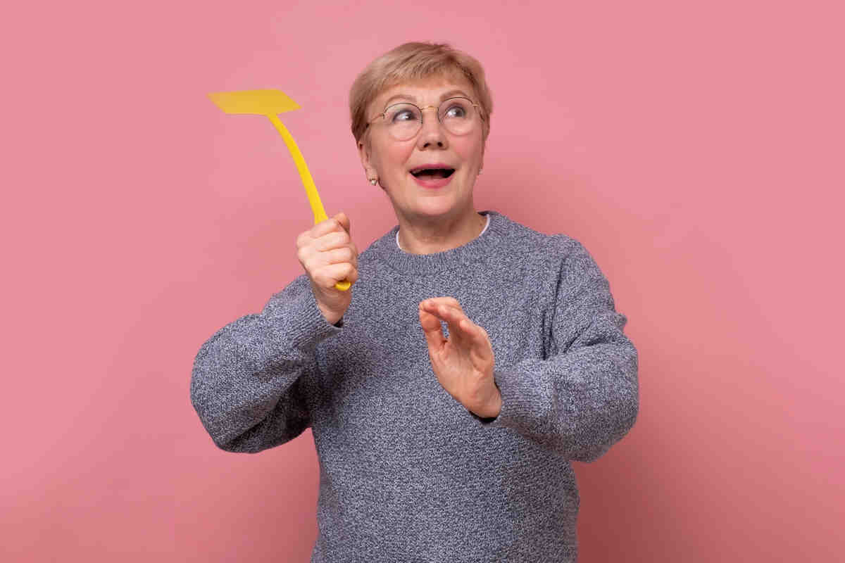 Mujer usando la paleta mata moscas.