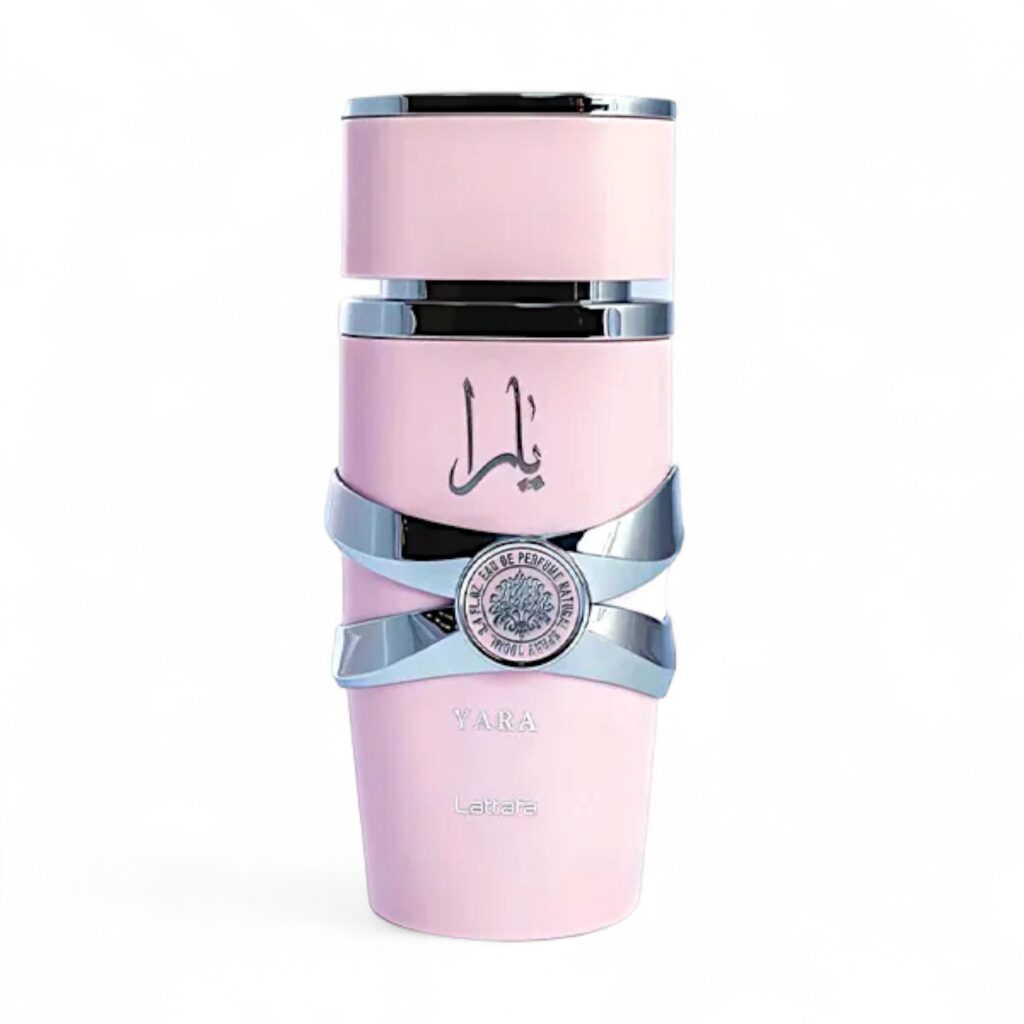 Un elegante frasco de Eau de Parfum Lattafa Yara Rosa en rosa pastel con detalles plateados y escritura árabe en la parte delantera, con un emblema redondo plateado y "YARA" y "Lattafa" en la parte inferior, perfecto como perfume de mujer, sobre un fondo blanco.