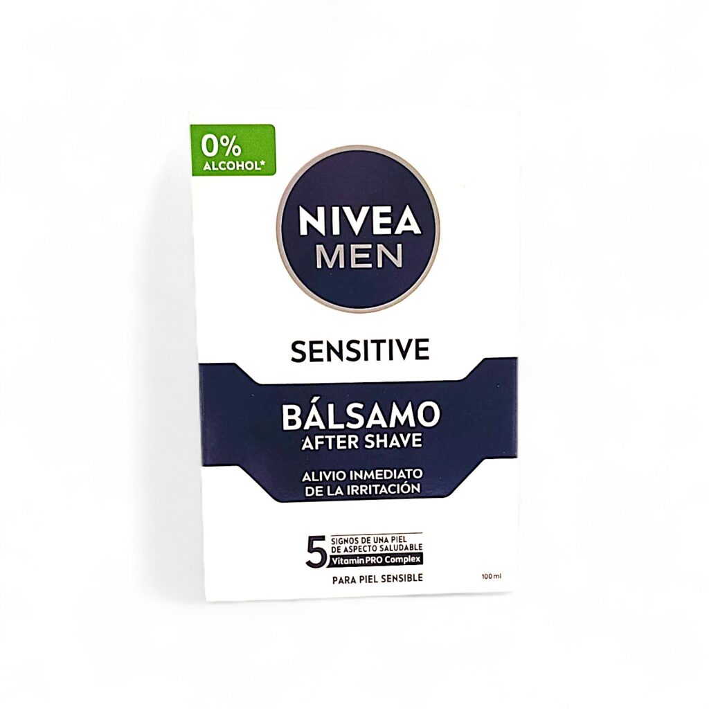 Una caja de bálsamo Nivea Men Sensitive After Shave, etiquetado 0% alcohol, proporciona un alivio inmediato de la irritación para pieles sensibles. El texto frontal está en español y destaca 5 signos de una piel de aspecto saludable.