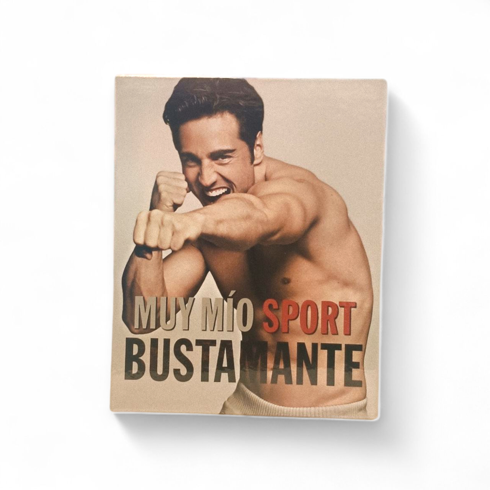 Un hombre sin camiseta sonriendo en una postura de boxeo protagoniza la portada de la caja de Bustamante Muy Mio Sport EDT 100ml sobre un fondo liso.