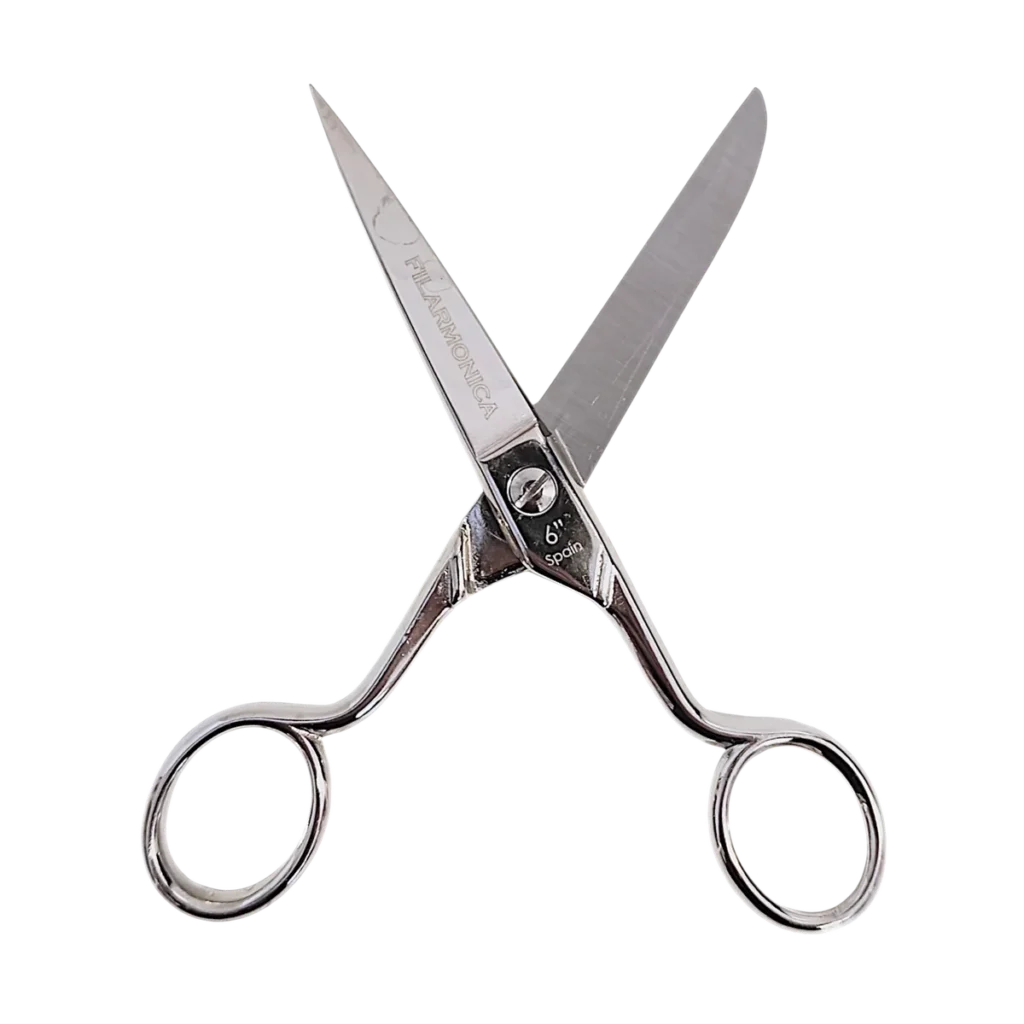 Un par de tijeras plateadas para cortar el pelo con hojas afiladas abiertas en forma de V, con dos orificios para los dedos y un apoyo para los dedos, aisladas sobre fondo transparente.