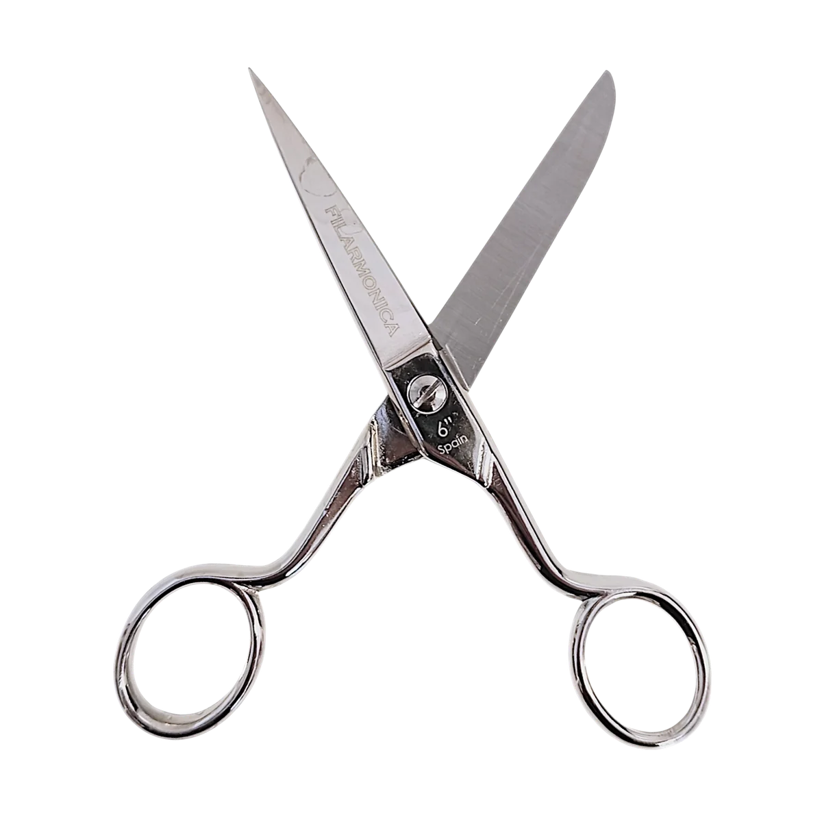 Un par de tijeras plateadas para cortar el pelo con hojas afiladas abiertas en forma de V, con dos orificios para los dedos y un apoyo para los dedos, aisladas sobre fondo transparente.