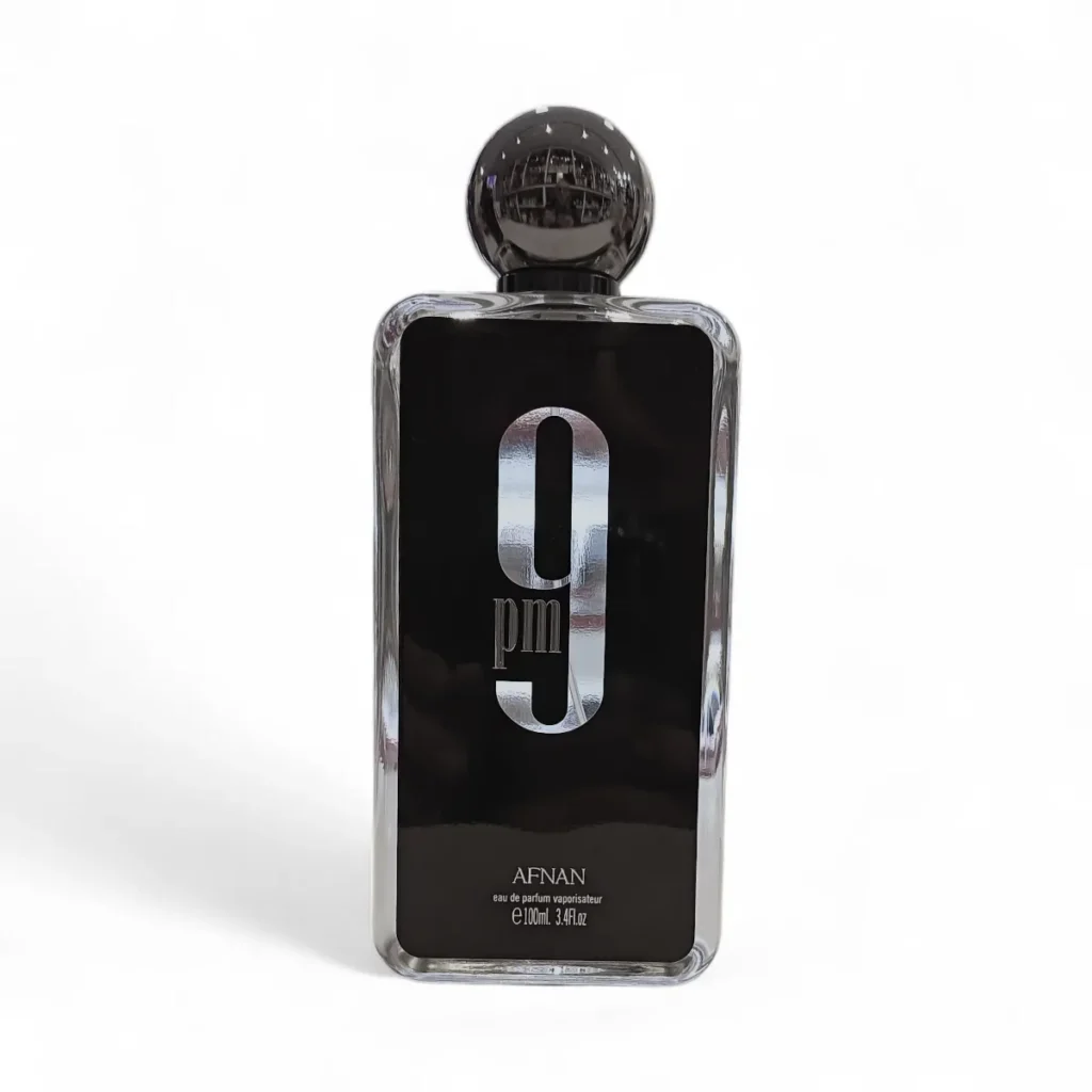 Afnan 9PM EDP 100ml es un frasco de perfume negro rectangular con un tapón redondo brillante, que presenta un gran "9PM" plateado en la etiqueta frontal y el nombre de la marca Afnan debajo.