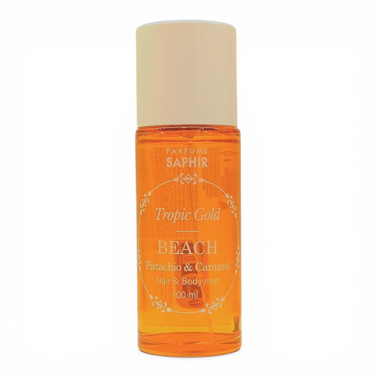 Un frasco de 100 ml de Parfums Saphir Tropic Gold BEACH Pistachio & Caramel Hair & Body Mist con un líquido ámbar anaranjado y un tapón beige, fotografiado sobre un fondo blanco.