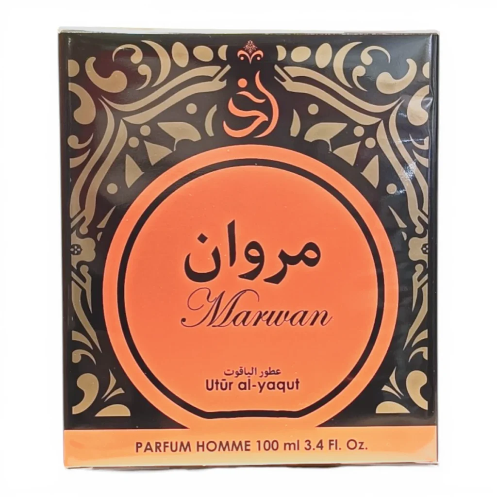 Un estuche de perfume con motivos ornamentales en negro y dorado que incluye Marwan en árabe e inglés, Utūr al-yaqut y PARFUM HOMME 100 ml 3.4 Fl. Oz. en una etiqueta circular naranja en el centro.