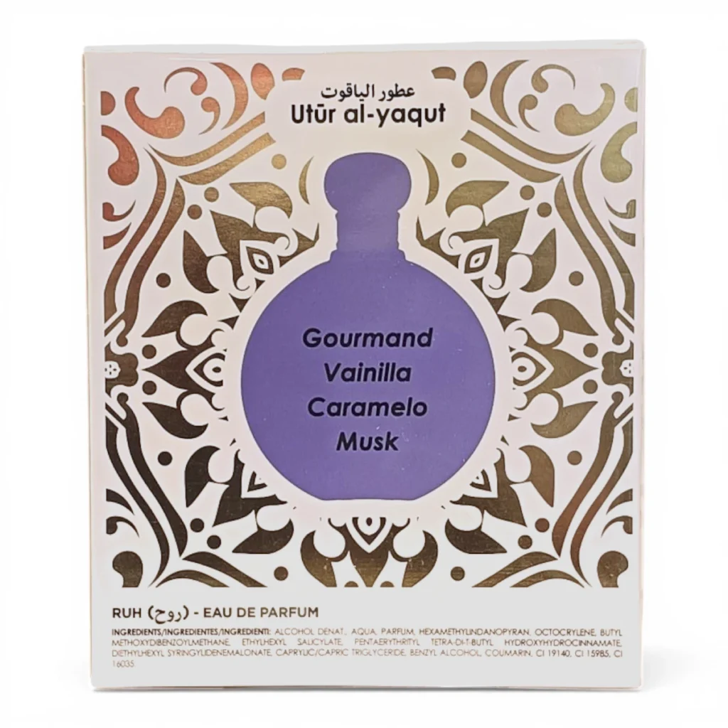 Caja de perfume con motivos ornamentales dorados, etiquetada Utūr al-yaqūt en la parte superior. En el centro aparece una ilustración de un frasco morado con las palabras Gourmand Vainilla Caramelo Musk. En la parte inferior se lee RUH Eau de Parfum.