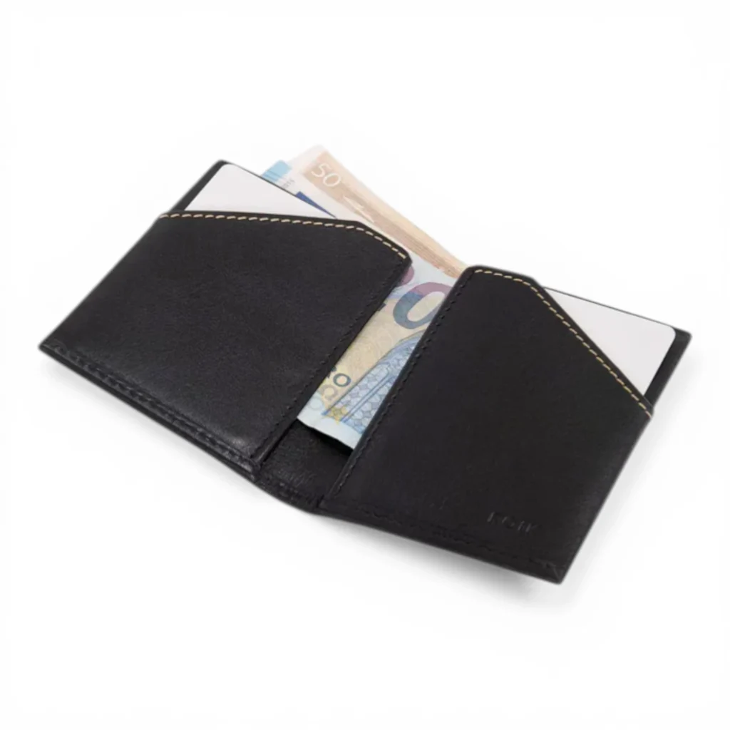 Una cartera de cuero negro está abierta, con billetes y tarjetas parcialmente metidos en los bolsillos, sobre un fondo blanco.